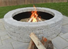 Unilock RomanStack Fire Pit used to create a circular fire pit design, showcasing rustic texture and warm tones for cozy outdoor living spaces at Old Station Landscape Supply.