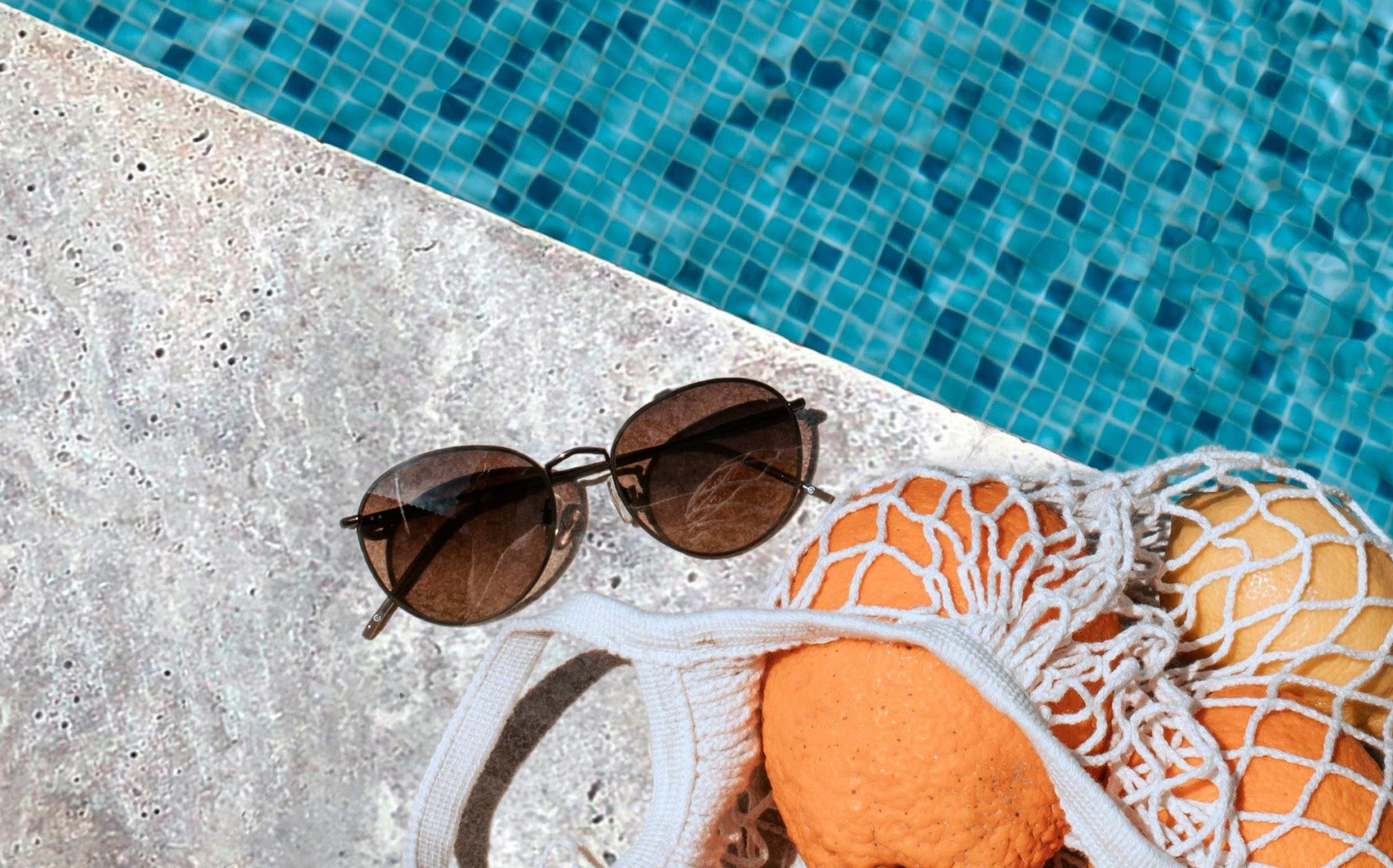 silver travertine paver and coping surrounding a pool with summer vibes