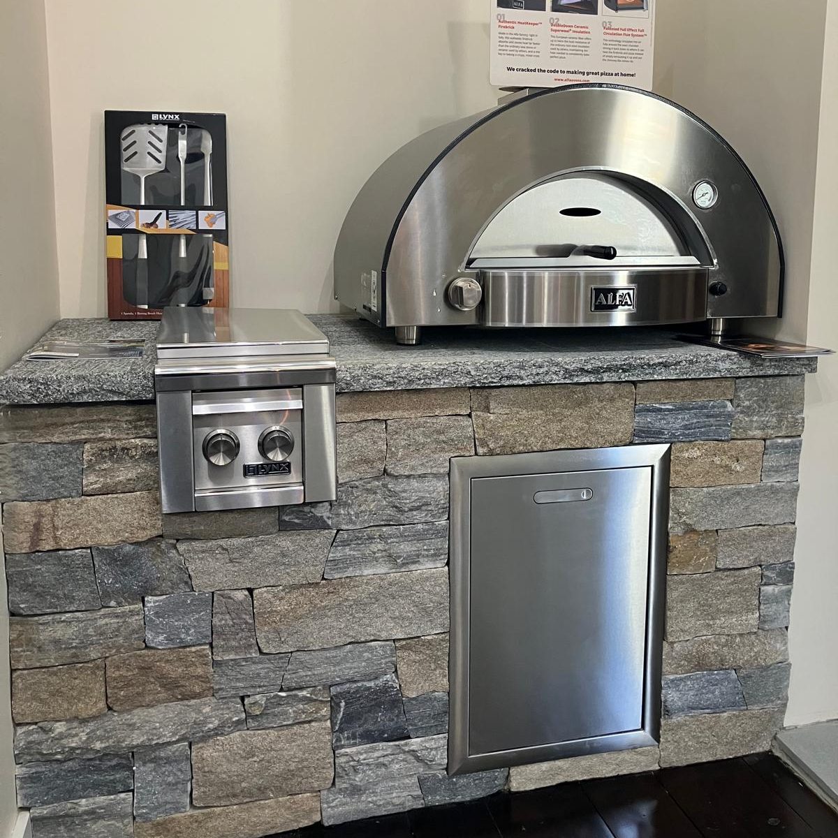 Alfa pizza oven silver and aluminum drawers with stone veneer framing at old station landscape supply indoor showroom