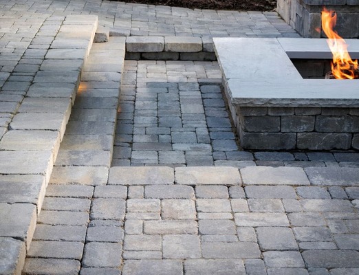 Outdoor patio with Belgard Dublin Cobble pavers surrounding a built-in fire feature