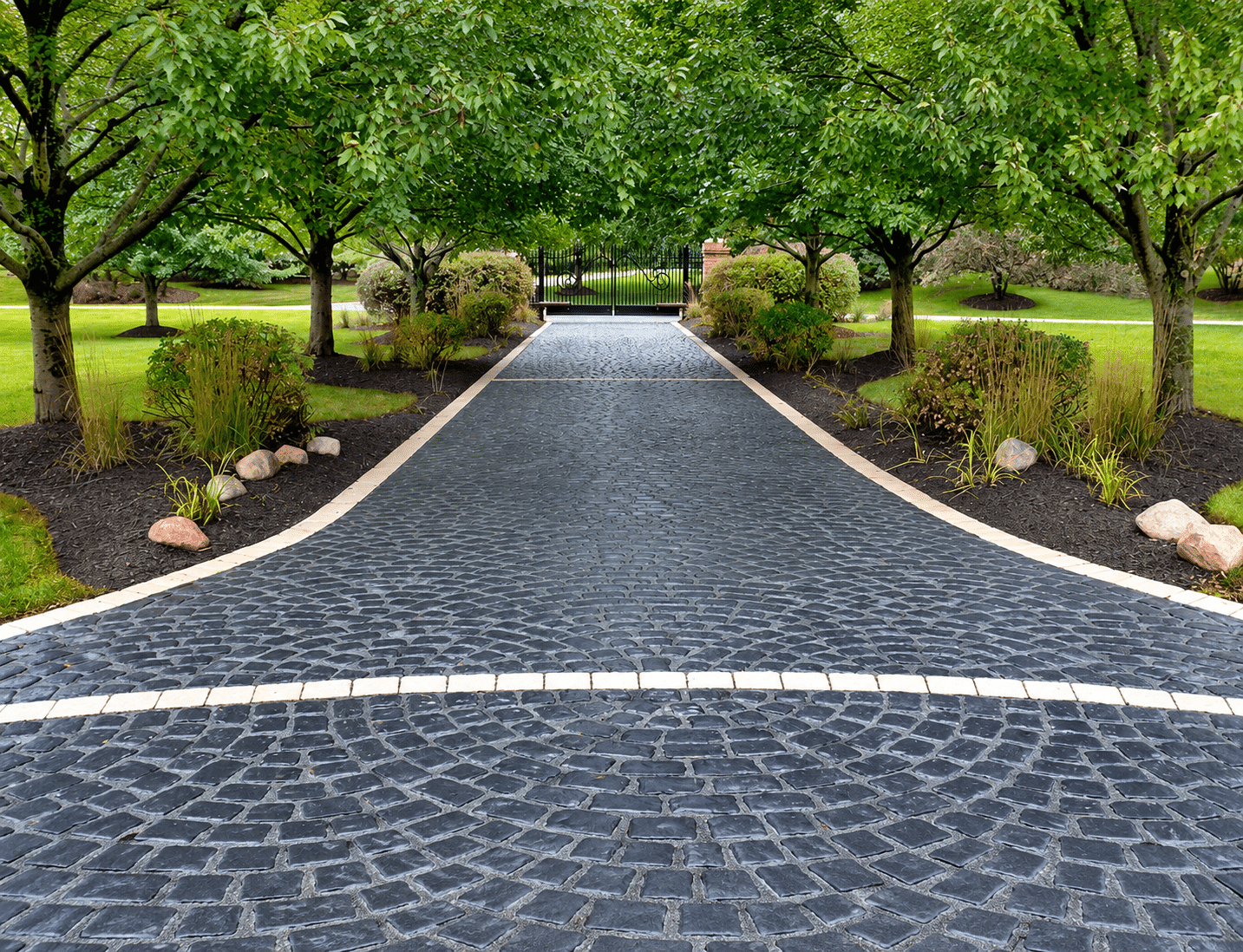 Driveway with Unilock COURTSTONE pavers in a dark cobblestone-style pattern