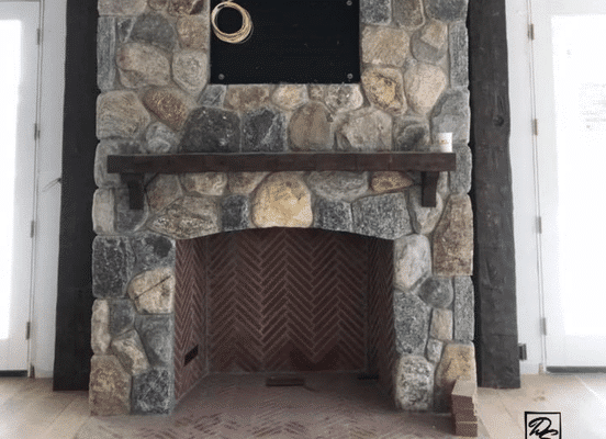 Photo of Cedar Creek River Rounds Natural Stone installed on an interior fireplace feature wall.
