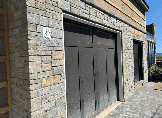 Photo of Dusty Rose Ashlar Natural Thin Stone Veneer installed on a residential garage exterior.
