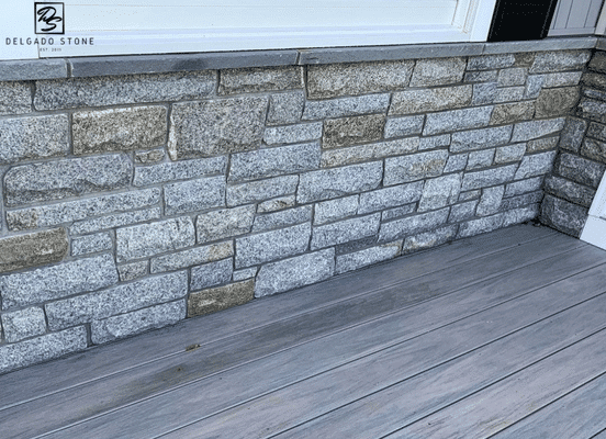 Photo of Dusty Rose Sawn Strip Natural Thin Stone Veneer installed on an exterior foundation wall.