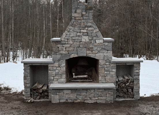 Photo of Fieldstone Dark Mixed Pattern Natural Thin Stone Veneer installed on an outdoor fireplace.