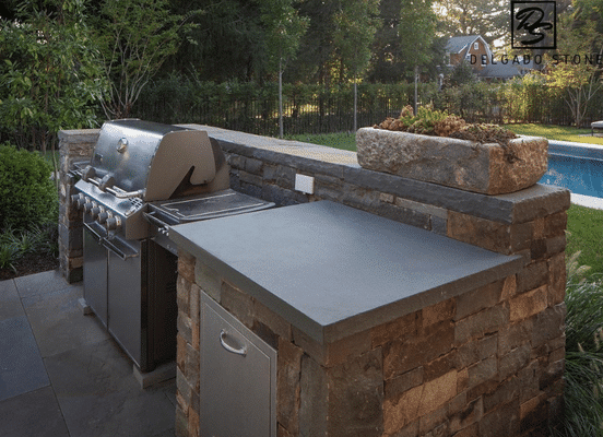 Photo of Fieldstone Dark Square and Rectangle Natural Thin Stone Veneer installed on an outdoor kitchen and grill station.