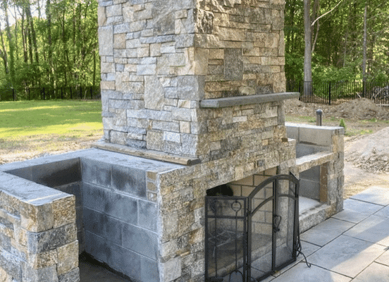 Photo of New York Blend Ashlar Natural Thin Stone Veneer installed on an outdoor fireplace.