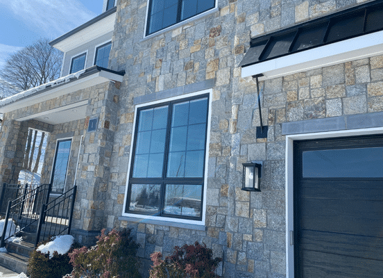 Photo of New York Blend Square and Rectangle Natural Thin Stone Veneer installed on a luxury home exterior.