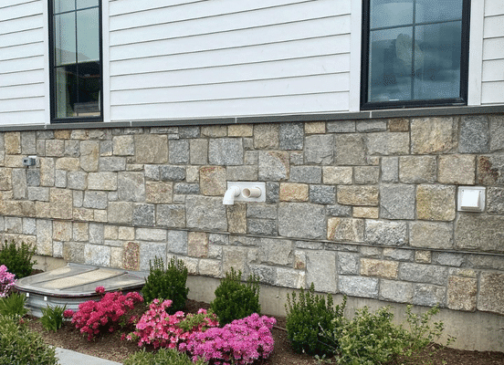 Photo of New York Blend Square and Rectangle Natural Thin Stone Veneer installed on a residential foundation wall.