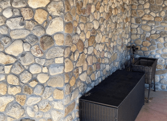 Photo of Newport River Rounds Natural Thin Stone Veneer installed on an interior stone accent wall.