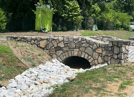 Photo of Nutmeg Ridge Mosaic Natural Thin Stone Veneer installed on a stone bridge over a drainage channel.