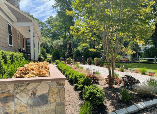 Photo of Nutmeg Ridge Mosaic Natural Thin Stone Veneer installed on landscape walls bordering a residential driveway.