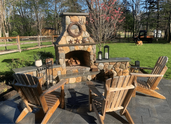 Photo of Old New England Rounds Natural Thin Stone Veneer installed on an outdoor fireplace space.