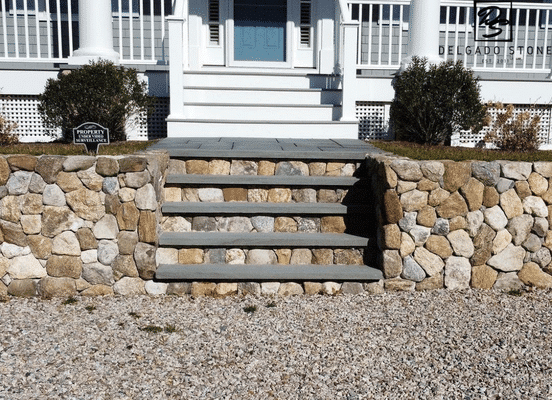 Photo of Old New England Rounds Natural Thin Stone Veneer installed on landscape stairs and retaining walls.