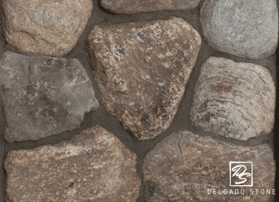 Close-up texture swatch of Old New England round fieldstones in earthy gray and tan tones.