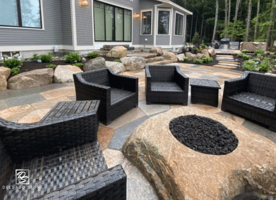 Old New England Wall sawn flagstone patio with natural boulder fire pit and outdoor seating area.