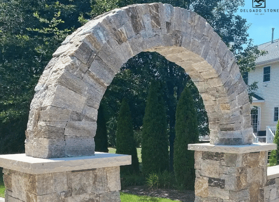 Photo of Colonial Tan Square and Rectangle Natural Thin Stone Veneer installed on a stone archway at the entrance of a house.