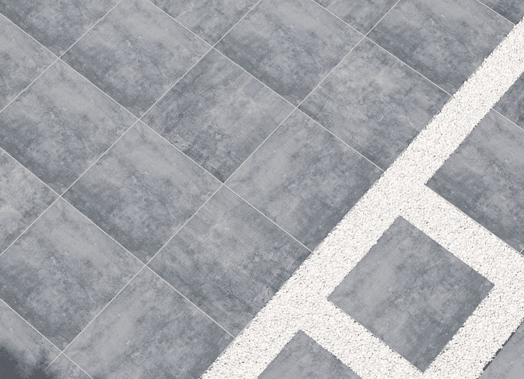 Arterra True Blue porcelain pavers installed in a geometric patio layout with decorative stone