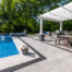 Unilock Umbriano pavers used for a poolside patio with an outdoor dining and kitchen area.